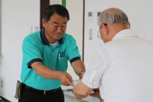 燕市社会福祉協議会の青柳会長に50万円の寄付を手渡す和平フレイズの和平社長(左)
