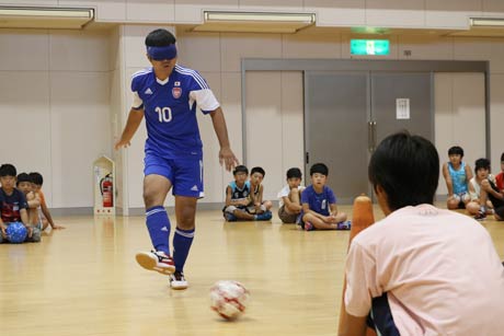 ブラインドサッカー日本代表の主将、落合啓士さんが手本を見せる