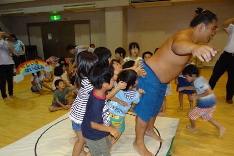 子どもたちに押されて土俵を割る力士