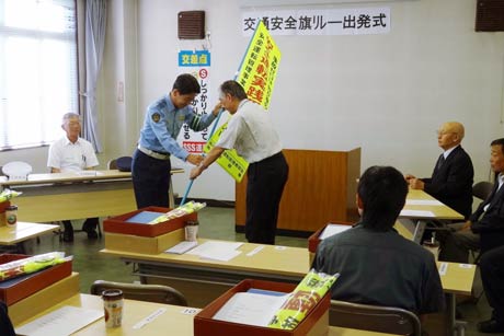 燕市交通安全協会による交通安全「旗」リレーの出発式、斉藤燕署長から旗を受け取る(株)やま電の安全運転管理者、樋山営業部長