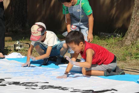 書道パフォーマンスで手形でコラボする子どもたち