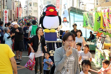 お披露目されたつばくろちゃんみこしが大通りを進む