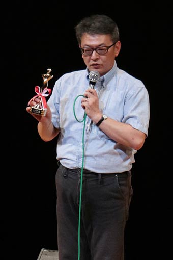 舞台あいさつを行う「牛のお医者さん」の時田監督、日本映画批評家大賞ドキュメンタリー賞のトロフィーを披露