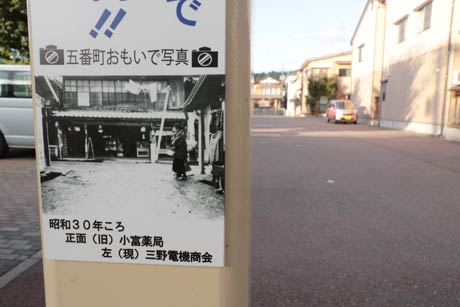 小富薬局があった昭和30年ころの風景の写真とその後ろに今はさら地になった同じ場所