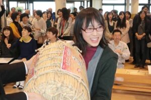 燕市の第8回料理コンクールに「黒米蒸しまんじゅう」で応募して2年ぶり2回目の最優秀賞に輝き、鈴木市長から副賞のコシヒカリ「飛燕舞」を受ける瀬倉さん
