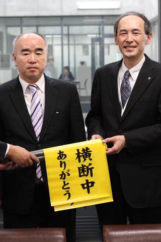燕市交通安全協会の小柳会長(左)から上原燕市教育長に交通安全横断手旗を贈呈