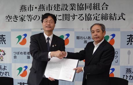 協定を結んで握手する燕市の鈴木市長(左)と燕市建設業協同組合の春木代表理事