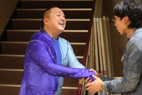 客を握手して送る山本さん