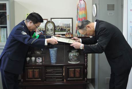 桜井署長から渡辺支店長に感謝状を手渡す