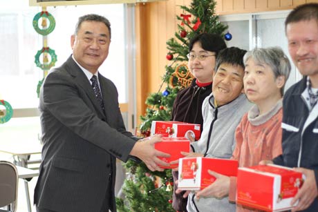  「つばくろの里」と「夢工場つばめ」の利用者にクリスマスケーキを手渡すローソン燕杣木店の長岡オーナー
