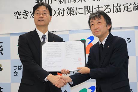  調定を交わして握手する鈴木市長(左)と新潟県司法書士会の外山会長