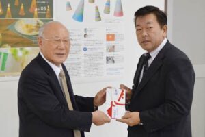 燕市社協の青柳会長(左)にチャリティーゴルフコンペで寄せられた30万円を手渡す燕運送の柳原社長