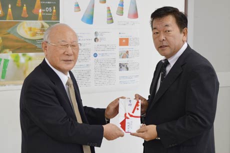 燕市社協の青柳会長(左)にチャリティーゴルフコンペで寄せられた30万円を手渡す燕運送の柳原社長