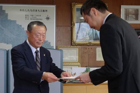 三条市体育協会の野崎会長(左)が国定市長に要望書を手渡す