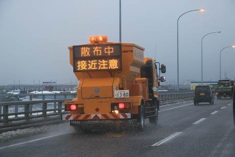  28日夕方、三条大橋上で融雪剤を散布する国交省の車両