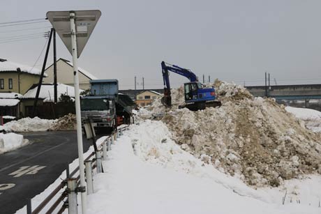河川敷を埋め立てるかのようにどんどん雪山が広がる