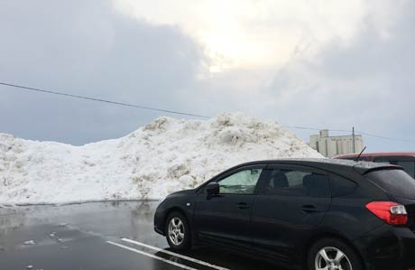 燕市役所駐車場は雪が消え、除雪の山が残る