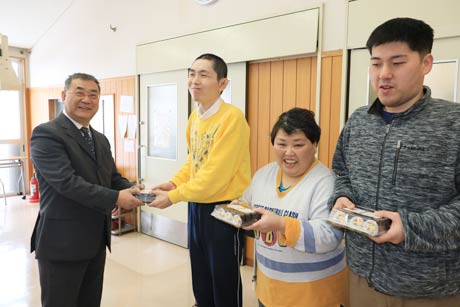 利用者に恵方巻を手渡すローソン燕杣木店オーナーの長岡さん(左)