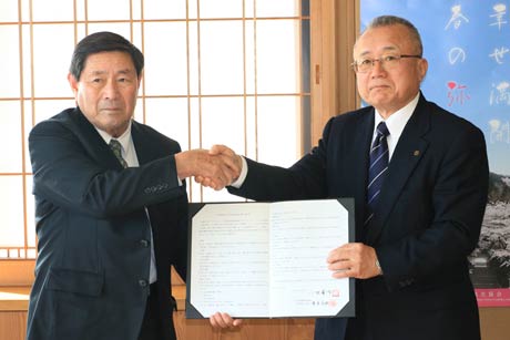  協定書に調印して握手する弥彦村建設業協同組合の菅原代表理事(左)と小林村長