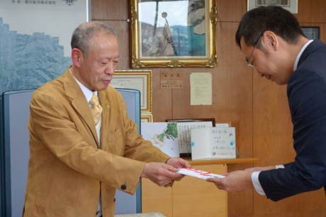 国定市長に10万円を手渡す高橋薫さん