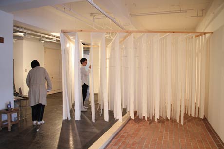 三条ものづくり学校に入居する服飾作家と空間デザイナーがエントランスでトイレットペーパーを使ったインスタレーション「織りなす空間」を制作中