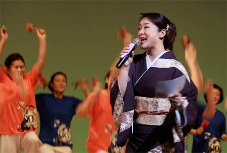 「舞燕」を歌う上杉香緒里さんとそれにあわせて演舞する燕市内のよさいこソーランの団体