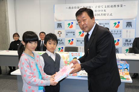 燕運送の柳原社長から代表の分水児童館を利用する児童2人に児童図書を贈呈