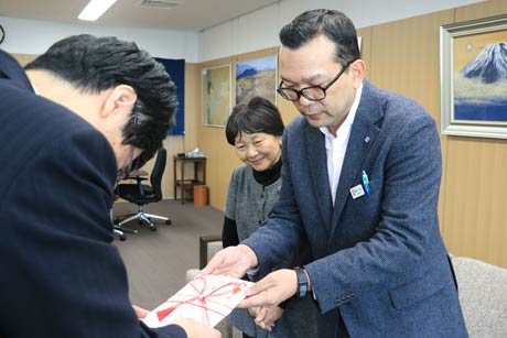 鈴木燕市長に100万円の寄付の目録を手渡す鳥部一誠さんと勝敏さん