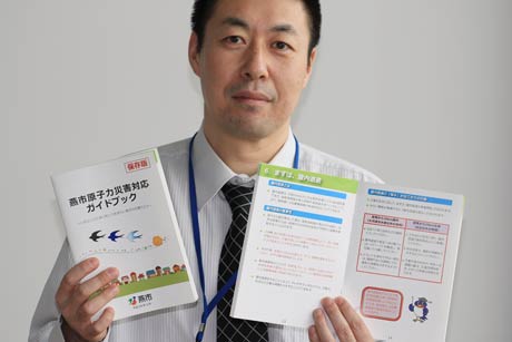 防災課の担当職員と『燕市原子力災害対応ガイドブック』