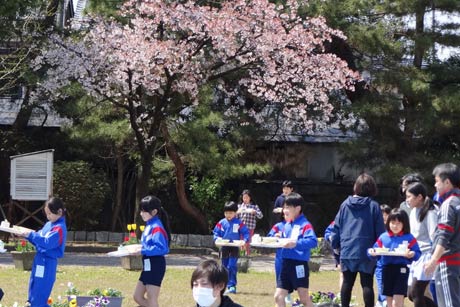 校庭に給食を運ぶ児童