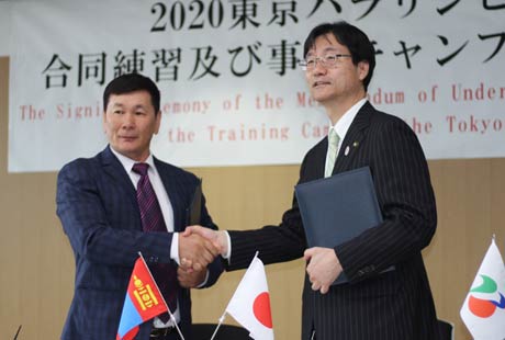 覚書に調印して握手するモンゴル国パラアーチェリー協会会長のバータルジャブさん(左)と鈴木市長
