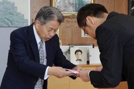 国定市長に三条市直江テニスコートに新築したクラブハウスの目録を手渡す松井社長