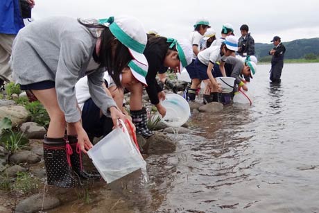  五十嵐川にアユ約6,000匹を放流する一ノ木戸小4年生