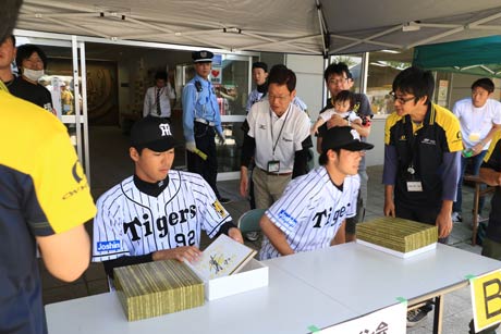 サイン会を行う田面巧二郎投手と伊藤和雄投手