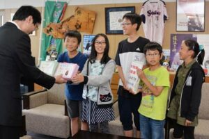 自主的に校内で熊本地震に充てる校内募金を行った燕市立分水北小学校6年生が集まった3万8千円余りを鈴木市長に託す