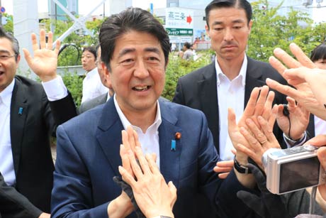 恒例のハイタッチを行う安倍首相