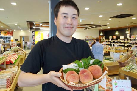 試食販売する初物のモモ