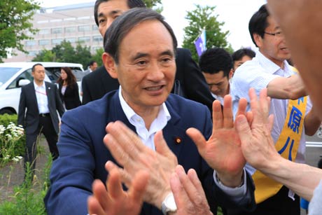 支持者とハイタッチする菅氏