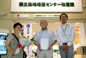 道の駅「燕三条地場産センター」の来館者10万人目となった藤倉さん夫婦(左)と亀井事務局長