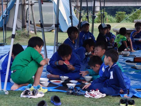 それぞれの学校の体操着で夕食を食べる