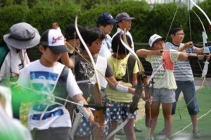 アーチェリー体験会で始めて矢を射る小中学生