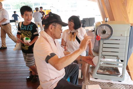  持参したかき氷機でかき氷を作る小林さん夫婦