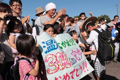 完歩を祝福、歓迎するメッセージを書いた紙を持参する家族も