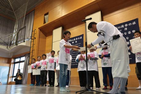 坂井団長から子どもたち一人ひとりに完歩賞を手渡す
