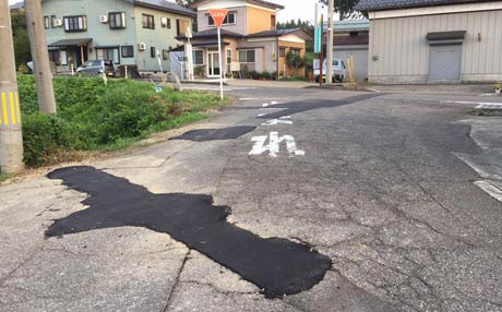 写真手前で水道工事が行われていてトラックが手前から奥の国道289号へ左折して出ようとしたところで交通誘導員を巻き込んだ