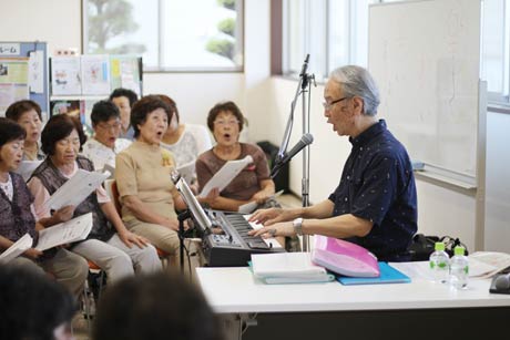 キーボードで伴奏、歌をリードする永田宏行さん