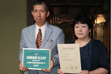 登録証と登録プレートを手に柄沢さん夫婦