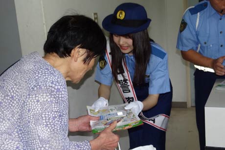 敬老会参加者に広報ちらしを手渡すミス雪椿クイーンの南雲さん