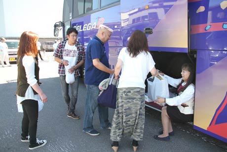 燕青空即売会で買い込んだ商品を観光バスに積み込む山形県南陽市の燕市訪問バスツアー「南陽市民号」参加者