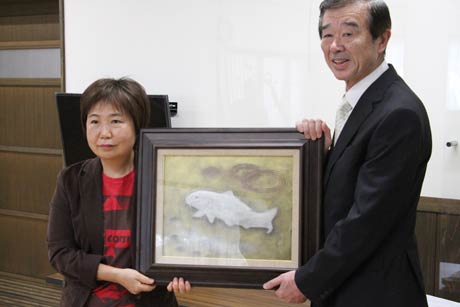 寄付した蒲舟氏の作品「鯉」を手にその孫にあたる亀倉芸さん(左)と社会福祉法人吉田福祉会の細貝理事長